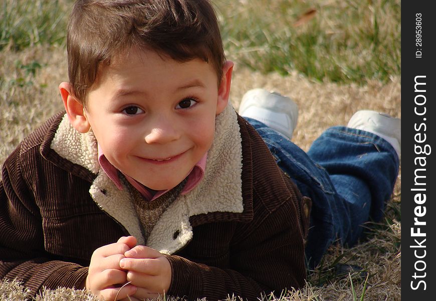 Happy little boy laying on the grass. Happy little boy laying on the grass