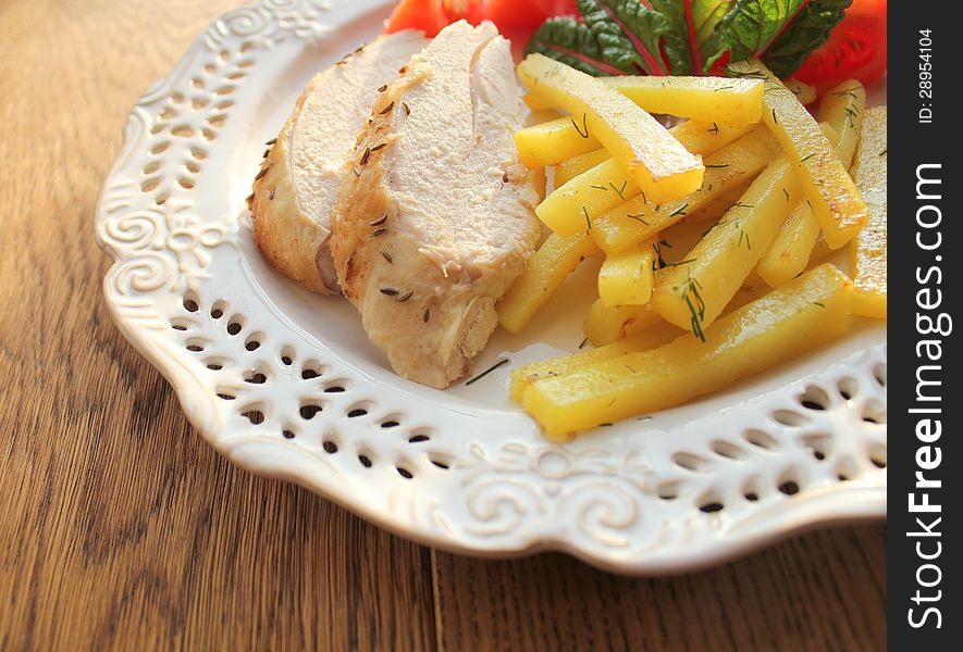 Sliced chicken breast with potatoes on plate