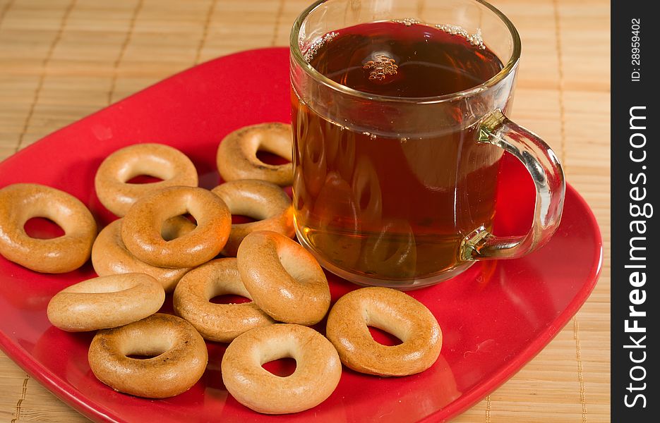 Bagel with tea on a red dish. Bagel with tea on a red dish