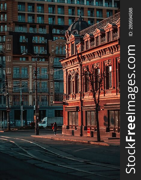 View of city street with tram tracks, and an old red building, evening time, Kyiv.