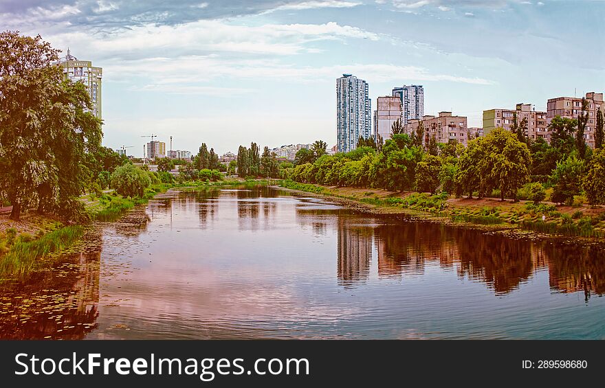 Beautiful view of the city river surrounded by trees and houses. nature background, copy space