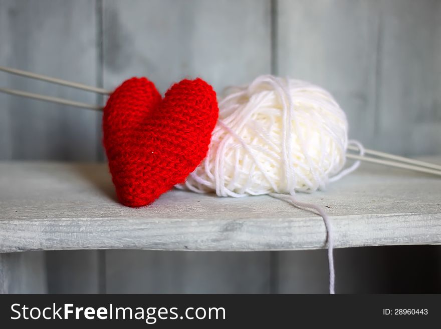 Photo of ball of wool and heart on wooden background