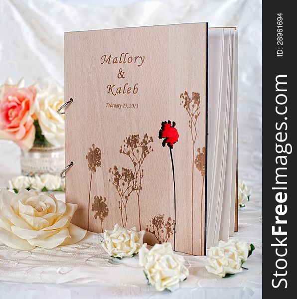 Wooden wedding guestbook with flowers in studio. Wooden wedding guestbook with flowers in studio