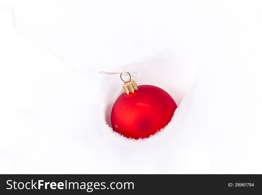 Red snowball/bauble in snow. Red snowball/bauble in snow.