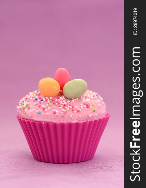 Easter cupcake on purple background with copy space