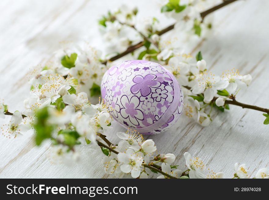 Easter eggs and branch with flowers on wooden background
