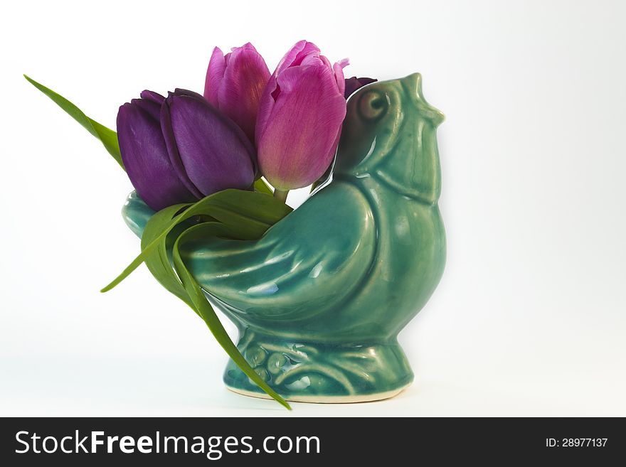 Antique ceramic blue bird with pink and purple tulips spring is in the air isolated on white background. Antique ceramic blue bird with pink and purple tulips spring is in the air isolated on white background