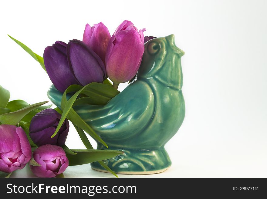 Antique ceramic blue bird with pink and purple tulips spring is in the air. Antique ceramic blue bird with pink and purple tulips spring is in the air
