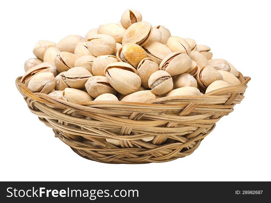 Pistachio nuts in a wicker plate, isolated on a white background