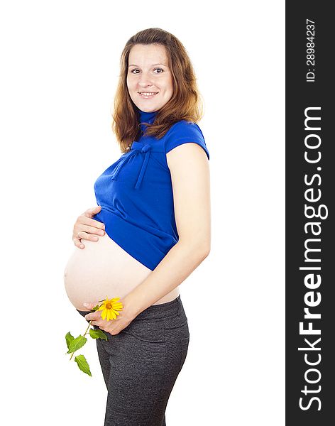 Pregnant woman stands with a flower and holding his stomach. Pregnant woman stands with a flower and holding his stomach