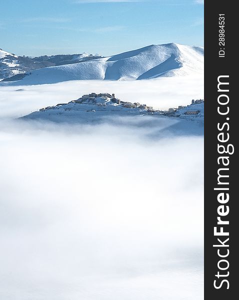 Snowy mountain above the clouds with a clear blue sky. Snowy mountain above the clouds with a clear blue sky
