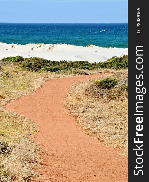 Landscape with red path leading to the beach...