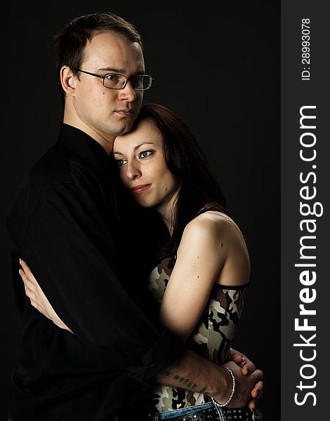 Portrait of young happy couple in studio on black background