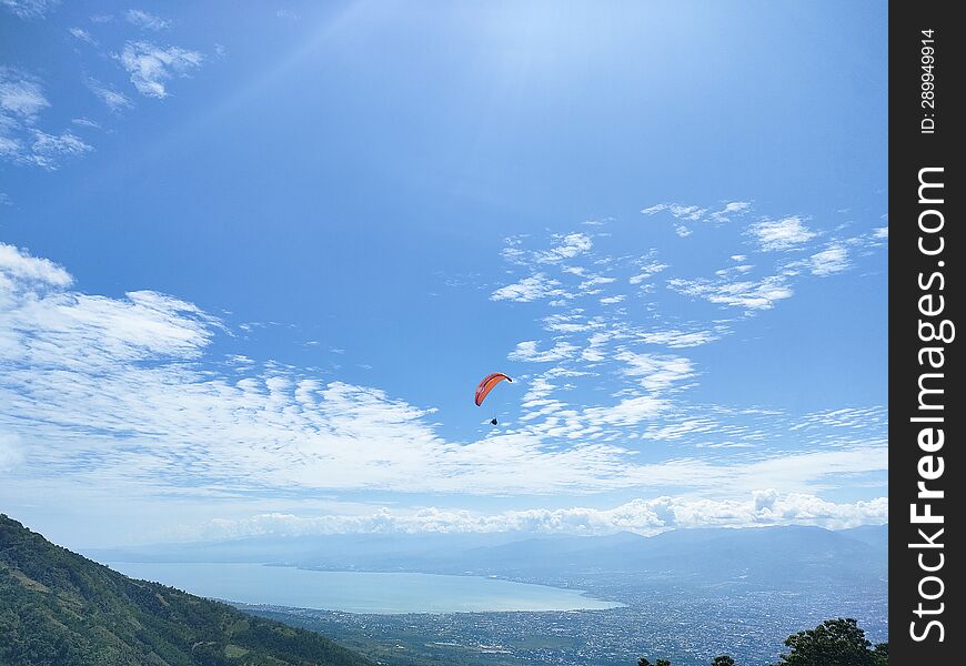 Living life on the edge, with the vast blue horizon below � paragliding, where the earth meets the heavens