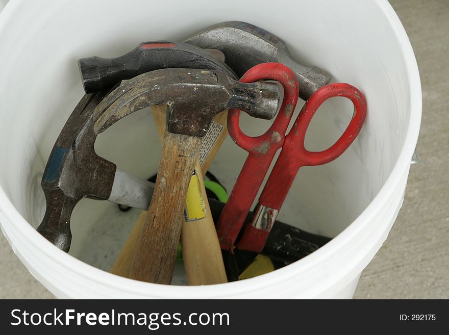 A bucket of hammers and snips. A bucket of hammers and snips