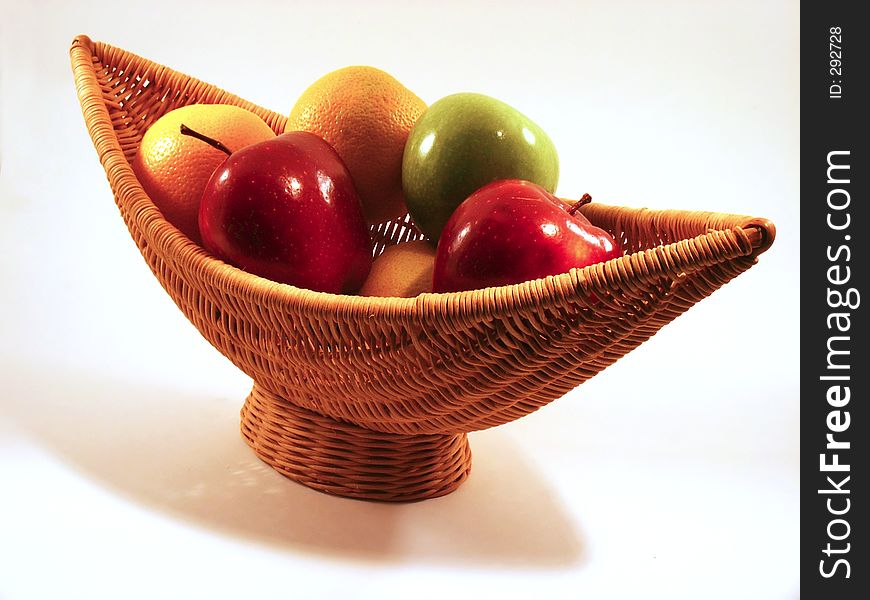 Green & red apples & oranges in crescent-shaped basket. Green & red apples & oranges in crescent-shaped basket
