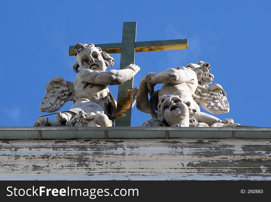 Angels around a cross on the roof of catholic church in St.Petersburg, Russia. Angels around a cross on the roof of catholic church in St.Petersburg, Russia.