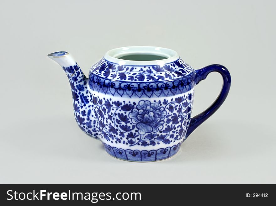 China teapot with cobalt blue handle and paintings.