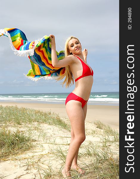 Photo of a model with a towel blowing in the breeze at the beach. Photo of a model with a towel blowing in the breeze at the beach.