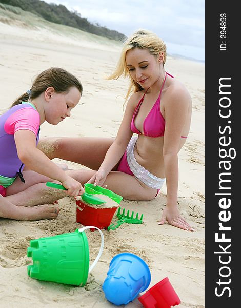 O of teen and child playing on the beach. O of teen and child playing on the beach.