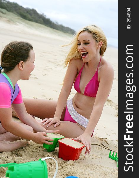 Photo of teen and child on the beach laughing. Photo of teen and child on the beach laughing.