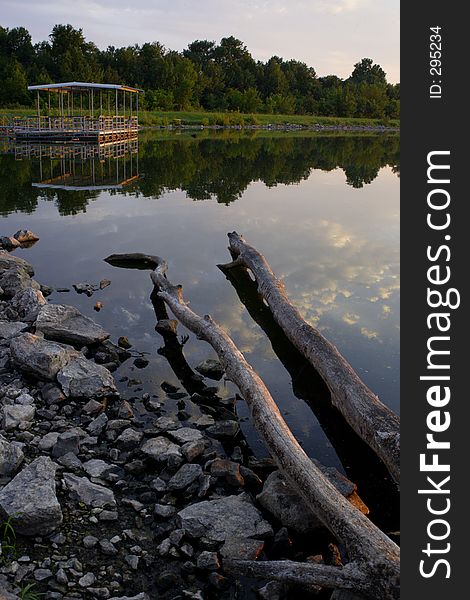 A boat dock on a calm lake at dusk. A boat dock on a calm lake at dusk.