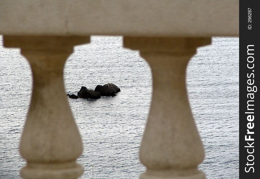 A fancy view on the sea rocks, watched through marble stylish fence. A fancy view on the sea rocks, watched through marble stylish fence