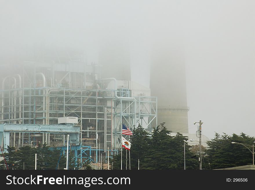 Power plant on a foggy morning at Moss Landing, California, with the US and California state flage in front. Power plant on a foggy morning at Moss Landing, California, with the US and California state flage in front.