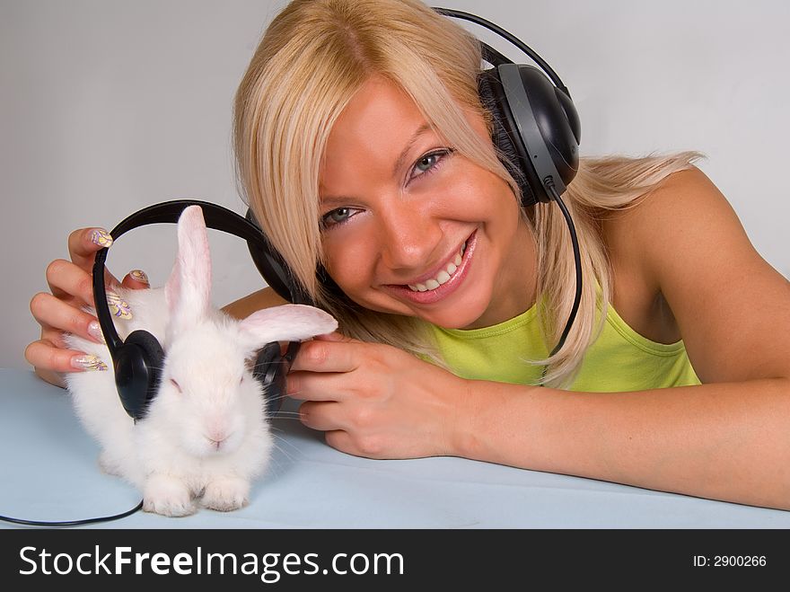 Cute blond and white rabbit listening to music. Cute blond and white rabbit listening to music