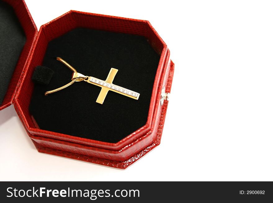 Golden and diamond cross in the jewelery box.