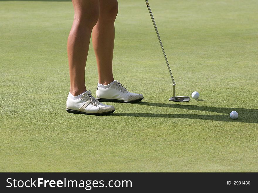 Lady golfer at the putting green. Lady golfer at the putting green