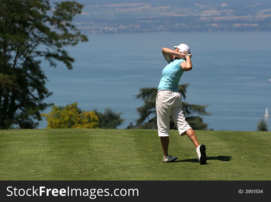 Lady golf swing over the Leman lake. Lady golf swing over the Leman lake