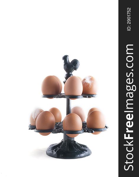 Many eggs in a green metal rack with chicken on top
