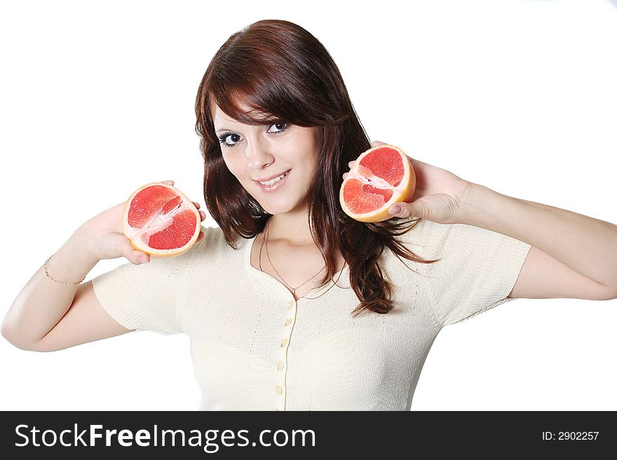 The beautiful girl holds half of grapefruit in hands. The beautiful girl holds half of grapefruit in hands