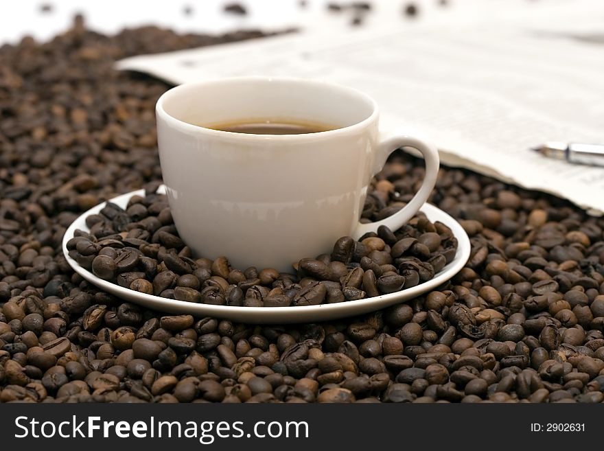 Coffe beans in cup on coffee background