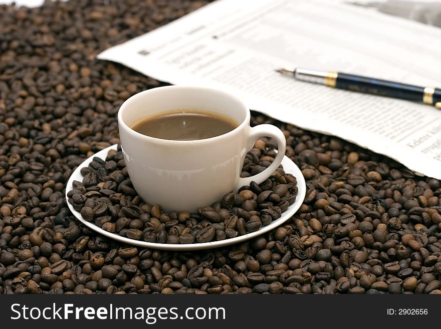 Coffe beans in cup on coffee background
