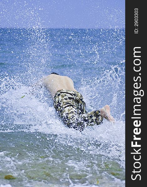 Young Man Jumping Into Sea Water