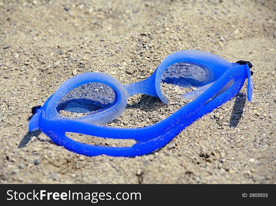 Blue Goggles Isolated in the Sand. Blue Goggles Isolated in the Sand