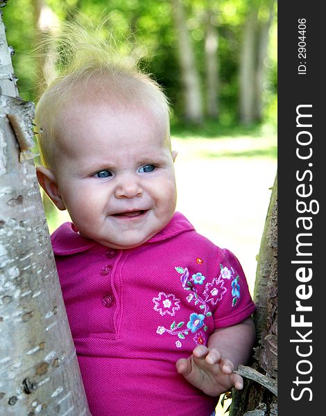 Baby Girl posing next to Tree