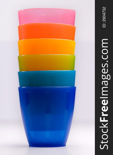 Colourfull plastic cups in a row, bright and cheery.