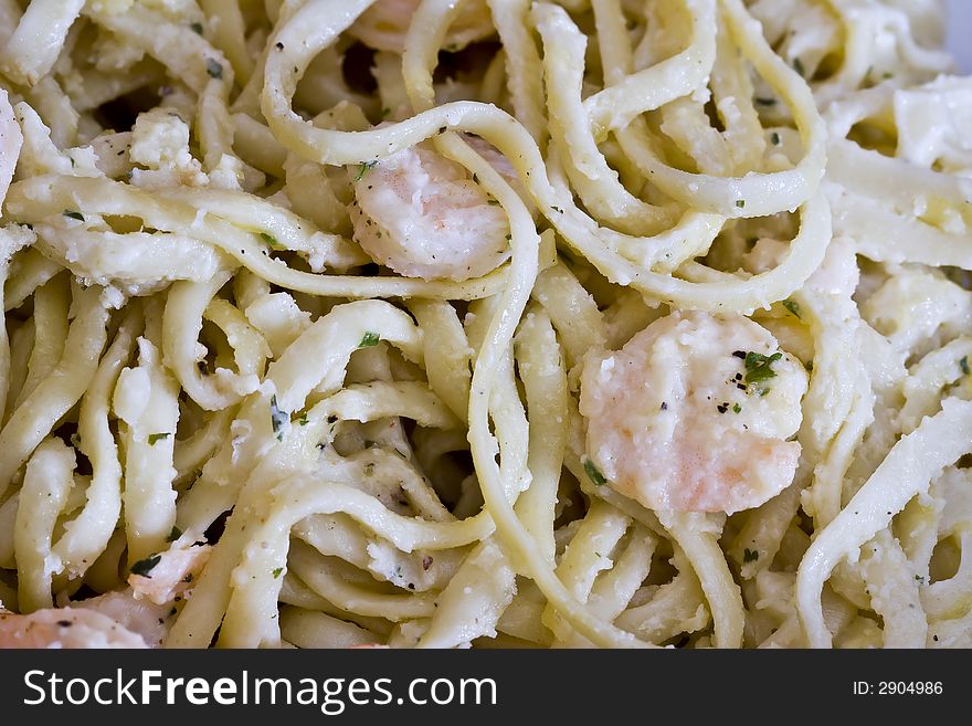 White plate full of shrimp pasta seasoned and hot. White plate full of shrimp pasta seasoned and hot