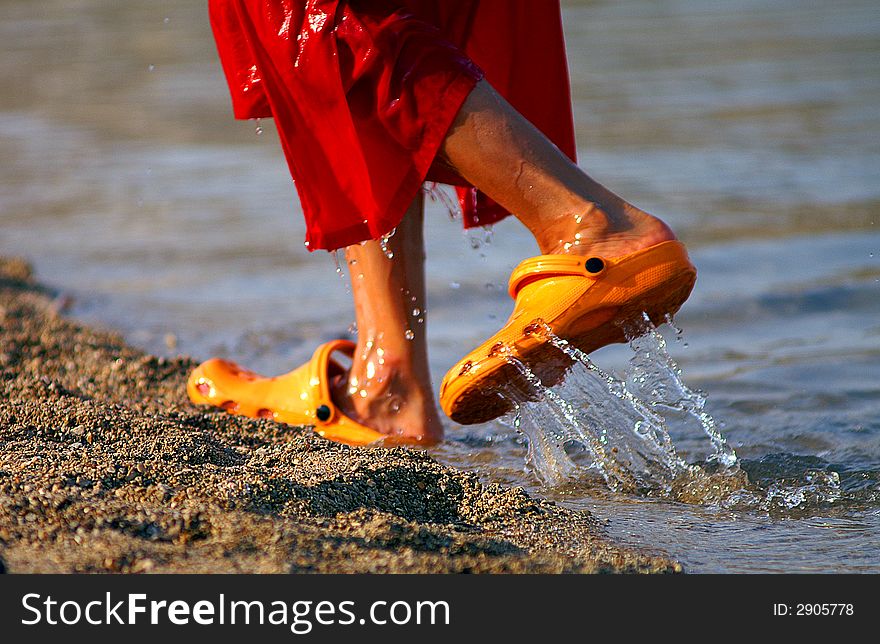 Colorful, yellow shoes stepping of the water. Colorful, yellow shoes stepping of the water