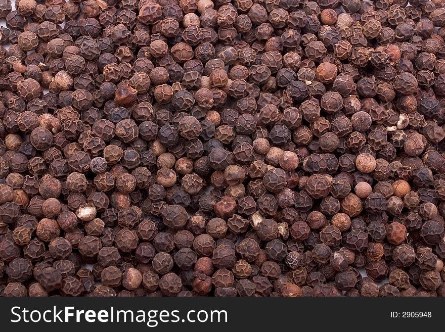 Close-up of dried black peppercorns, filling the frame