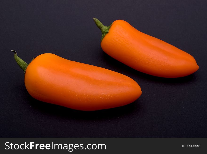 Orange sweet peppers, isolated on black