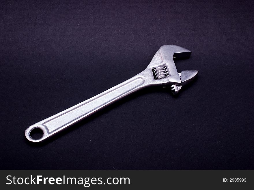 An adjustable spanner, isolated on black