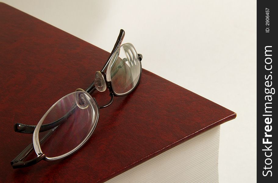 Book with pair of glasses on top. Book with pair of glasses on top