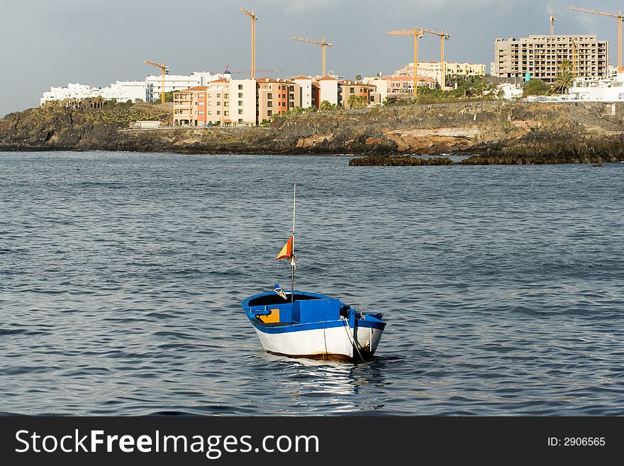 Small dinghy moored in front of new hotels being built. Small dinghy moored in front of new hotels being built