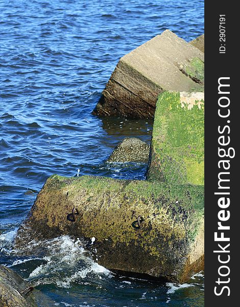 Concrete blocks of pier with waves