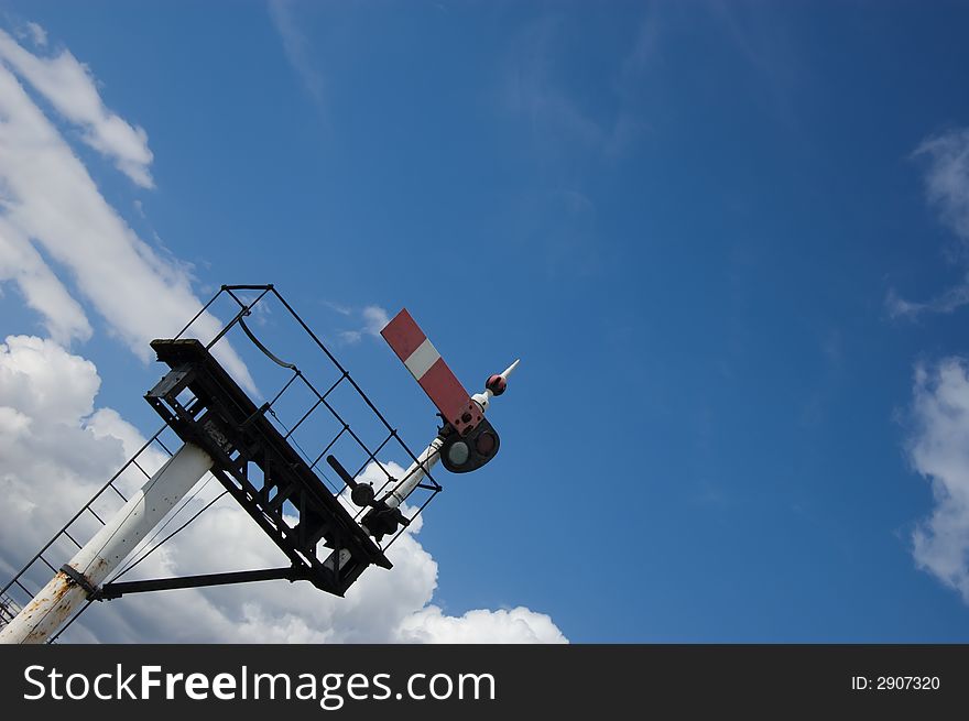 British semaphore Home Signal on a gantry set against a blue sky
