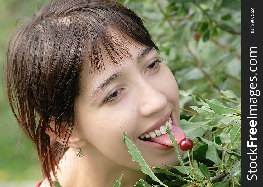 The girl is teasing, concerning a ripe cherry